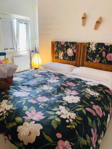 - une chambre dotée d'un grand lit avec un couvre-lit floral dans l'établissement Al Volo B&B, à San Giovanni Teatino