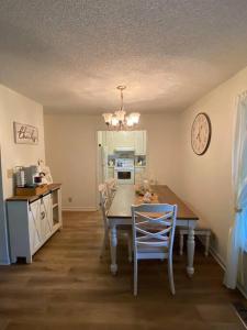 una cocina con mesa y sillas y un reloj en la pared en Your Own Lakehouse, en Macon