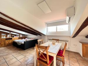 a living room with a table and chairs and a bed at Ático Atocha Ile in Madrid