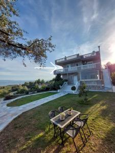 una mesa y sillas frente a una casa en Διαμερισμα με θεα Ερετρια, en Eretria