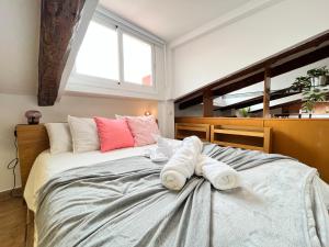 una camera da letto con un grande letto con asciugamani di Ático Atocha Ile a Madrid