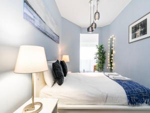 カスカイスにあるBeach Cascais Apartmentのベッドルーム(白いベッド1台、ランプ付)