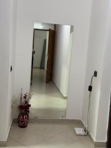 a hallway with a door and a vase on the floor at Golem Getaway Apartment in Golem