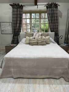 een groot bed met kussens in een slaapkamer bij New luxury self-contained studio in South Cadbury