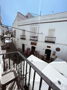 a balcony of a white building with a table and chairs at Casa Melo in Tarifa