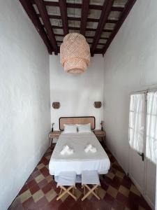 a bedroom with a bed and a chandelier at Casa Melo in Tarifa