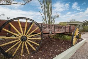 an old wooden wagon sitting in a garden at Sagebrush Inn in Tombstone