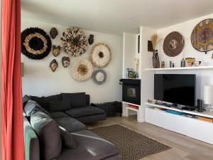 a living room with a couch and a flat screen tv at CaLoura 76 in Lagoa