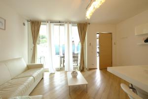 uma sala de estar com um sofá e uma mesa em MIMA61 - Appartamento con giardino e posti auto a 50mt dal centro em Milano Marittima