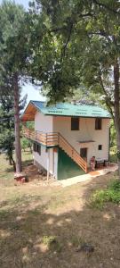 uma pequena casa com um telhado verde num campo em Kuca idealna za odmor i uzivanje u Vrdniku broj 4 em Vrdnik