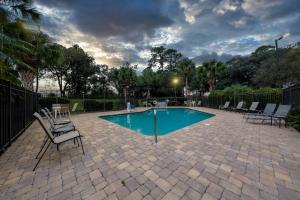- une piscine avec des chaises à côté d'une clôture dans l'établissement Red Roof Inn Tampa - Brandon, à Tampa