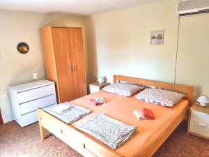 a bedroom with a wooden bed with two pillows at House Lopica in Senj