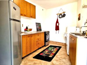 a kitchen with a refrigerator and a rug on the floor at House Lopica in Senj