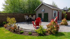 a patio with chairs and a table in a backyard at Wild Pacific Guest Suites in Ucluelet