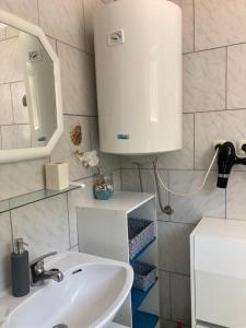 baño con lavabo y armario blanco en Apartmani Fijan en Pag