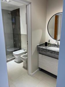 a bathroom with a toilet and a sink and a mirror at Departamento premium para 3 personas in Puerto Madryn +10 photos