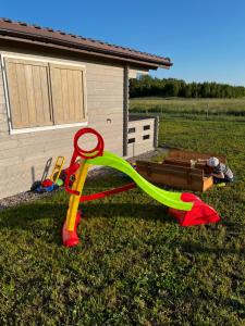 a childs play equipment in the grass in front of a house at Domki Me Mazury in Giżycko