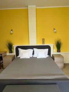 a bedroom with a large bed with yellow walls at Valentino´s Residence in Constanţa
