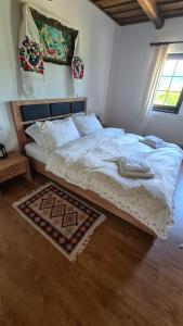 a bed in a bedroom with a rug on the floor at Casa bunicilor din Oncești in Onceşti