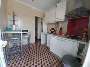 a kitchen with white cabinets and a checkered floor at Casa do Portão Azul - Tamboril in Atouguia da Baleia +38 photos
