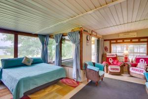 een slaapkamer met een bed en een bank en stoelen bij Cozy Lake Eufaula Hideaway with Fire Pit and Hot Tub! in Eufaula