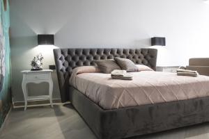 a bedroom with a bed with a tufted headboard and a table at Incanto Luxury Rooms in Lampedusa