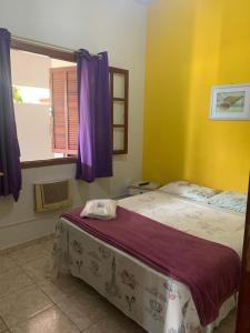 a bedroom with two beds and a window at Pousada Recanto do Mar in Saquarema