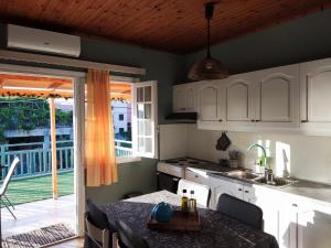 a kitchen with white cabinets and a table with a tableablish at Seaside Escape Apartment in Gournes