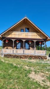 a large wooden house with red bows on it at Casa bunicilor din Oncești in Onceşti