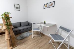 a living room with a couch and a table and chairs at Apartman Ana Osijek in Osijek