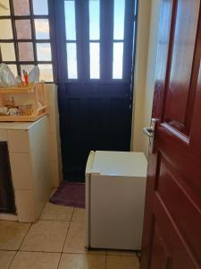 a door to a kitchen with a refrigerator in a room at Tashie homes in Machakos