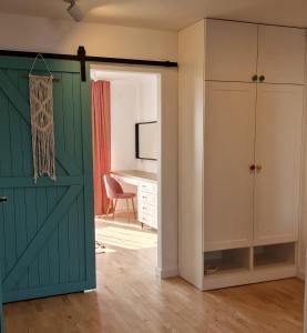 uma porta de celeiro aberta num quarto com uma secretária em Apartament Boho em Bilgoraj