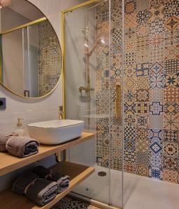 uma casa de banho com um lavatório e uma cabina de duche em vidro. em Apartament Boho em Bilgoraj