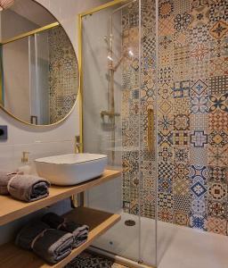 a bathroom with a sink and a glass shower at Apartament Boho in Biłgoraj +15 photos