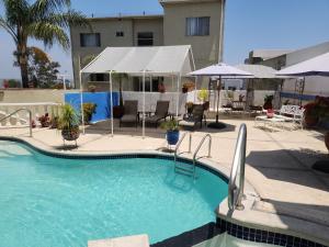 a large swimming pool with chairs and umbrellas at Sadie's Bed and Breakfast / Hotel in Tijuana