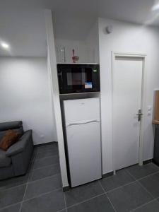 eine Küche mit einer Mikrowelle auf der Theke in der Unterkunft Petite maison avec jardin in Montluçon