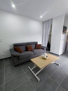 un soggiorno con divano e tavolo di Petite maison avec jardin a Montluçon
