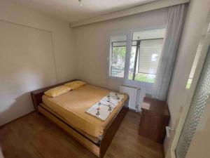 a small bedroom with a bed and a window at Dikili Sahilde Denize Sıfır Daire in Dikili