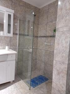 La salle de bains est pourvue d'une douche avec une porte en verre. dans l'établissement Departamento Balcarce, à Cipolletti