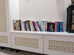 a white book shelf with books on it at Weinloft Ehrenhausen in Ehrenhausen