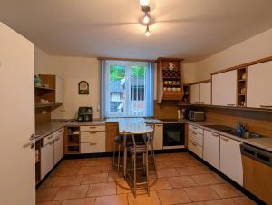 een keuken met witte kasten en een tafel. bij Weinloft Ehrenhausen in Ehrenhausen