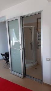 a bathroom with a shower and a glass door at ATCA House in Bucharest