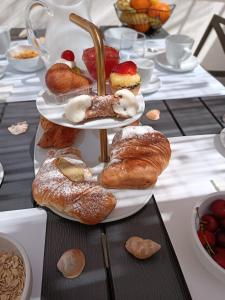 une table garnie de assiettes de pâtisseries et de desserts dans l'établissement Clio's House - Mondello, à Mondello