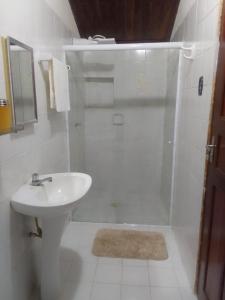een witte badkamer met een wastafel en een douche bij Casa Colonial no Centro in Carolina