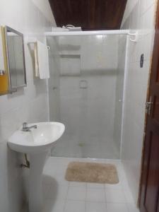 a white bathroom with a sink and a shower at Casa Colonial no Centro in Carolina