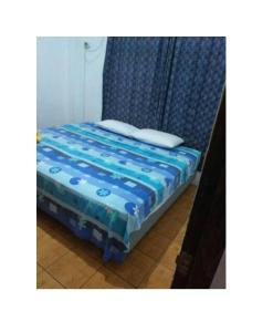 1 cama pequeña con edredón azul en una habitación en Casa Puerto Ayora, en Puerto Ayora
