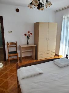 1 dormitorio con 2 camas, armario y silla en Lake Ohrid Guesthouse "Villa Valentina", en Pogradec