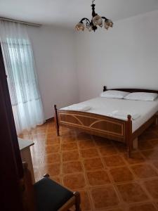 a bedroom with a bed and a wooden floor at Lake Ohrid Guesthouse "Villa Valentina" in Pogradec