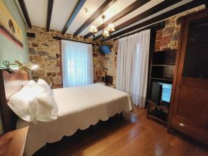 1 dormitorio con 1 cama y TV en Posada el Remanso de Trivieco, en La Cavada