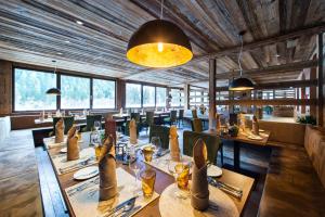 a dining room with tables and chairs and windows at Alphotel Tyrol in Racines